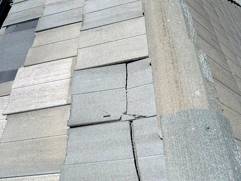 Cracked and broken concrete roof tiles alongside a solar panel array on a Kerman home