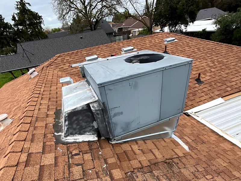 A rooftop unit and duct plenum on a Stockton shingle roof, sealed with smeared mastic instead of proper flashing