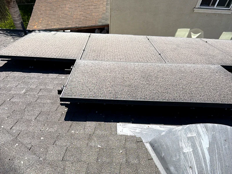 A solar array on a Stockton shingle roof beside a metal patch coated in smeared sealant